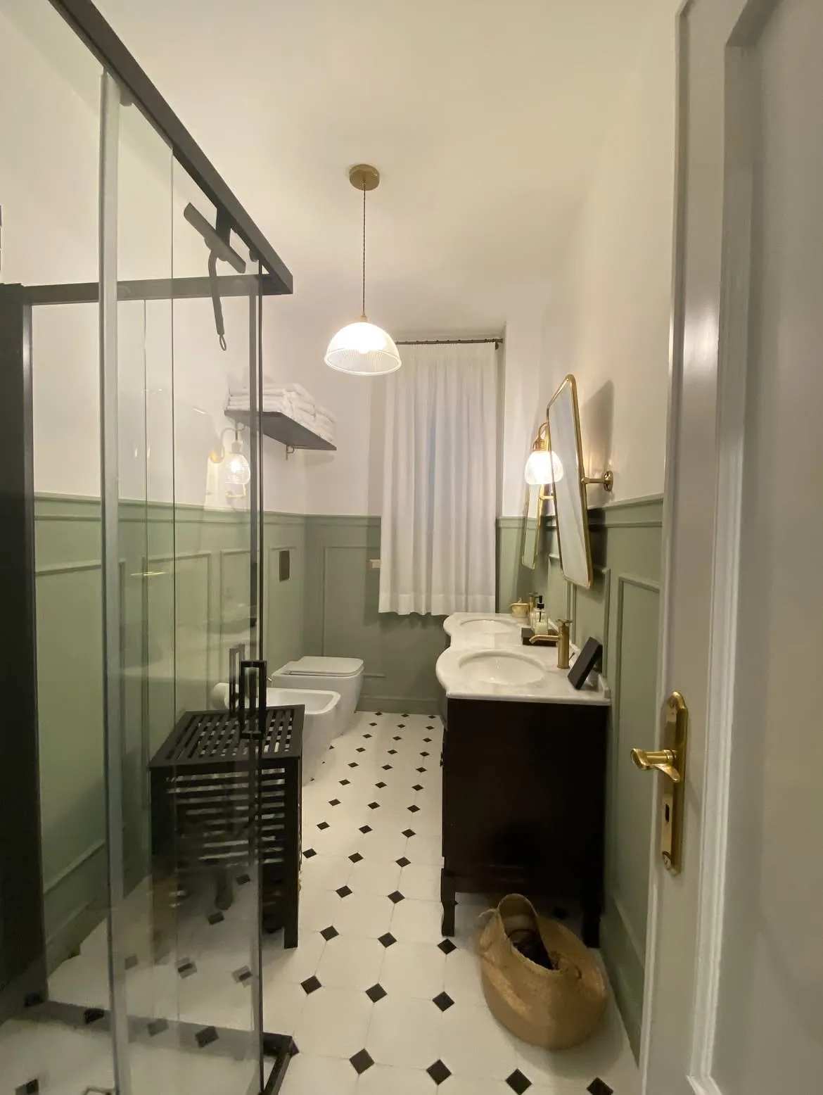 Bagno verde salvia con tenda in lino bianco, vista dalla doccia